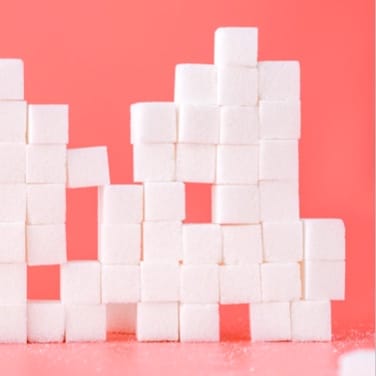 several sugar cubes on pink background