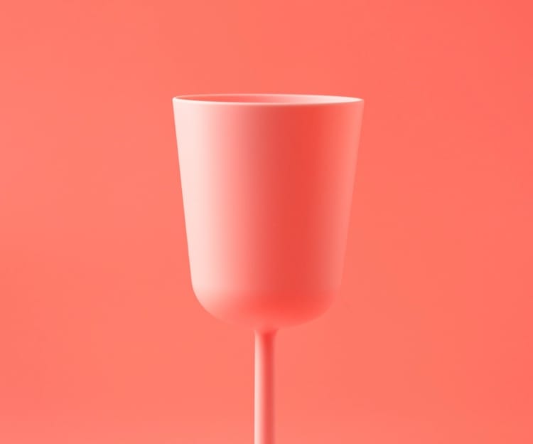 Pink wine glass on soft red background