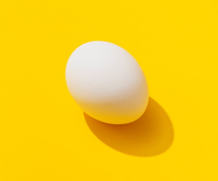 White egg on yellow table